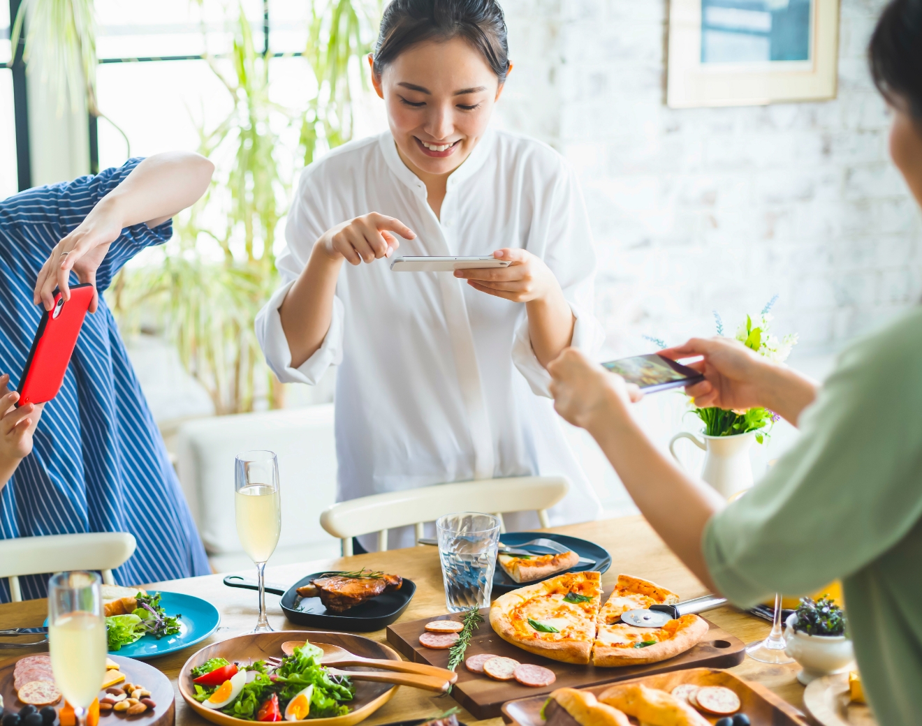 スマホでパーティーの料理を撮影している様子