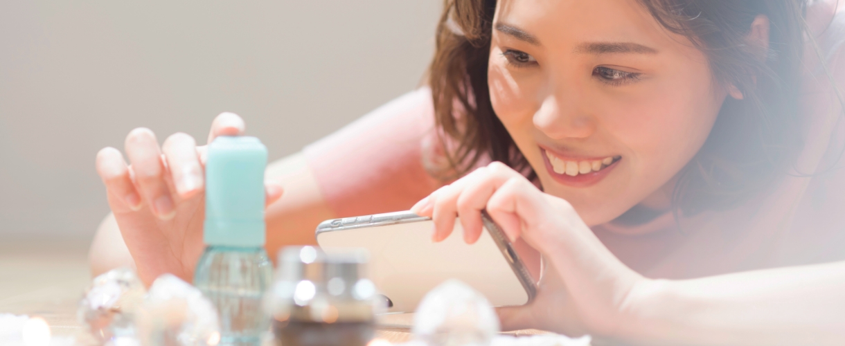 女性が美容品をスマホで接写している様子