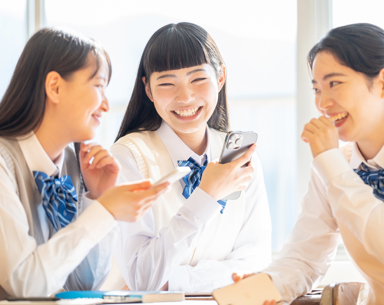 スマホを見て盛り上がる女子高生たち